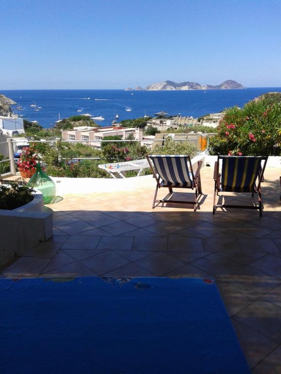 2 Stühle auf einer Terrasse mit Meerblick in der Unterkunft Casadelpino Residence La Piana in Ponza