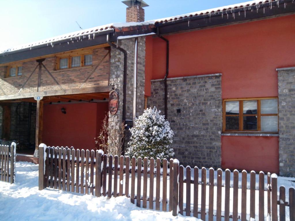 a house with a fence in the snow at Hostal Casa La Picota in Cofiñal