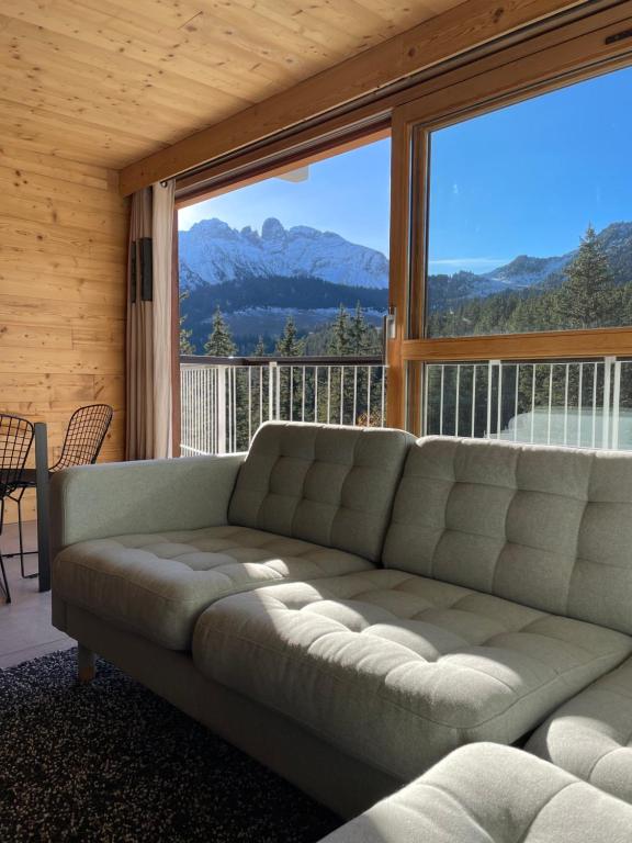 - un canapé dans une chambre avec une grande fenêtre dans l'établissement Résidence LE ROC SABAL - Courchevel 1650, à Courchevel