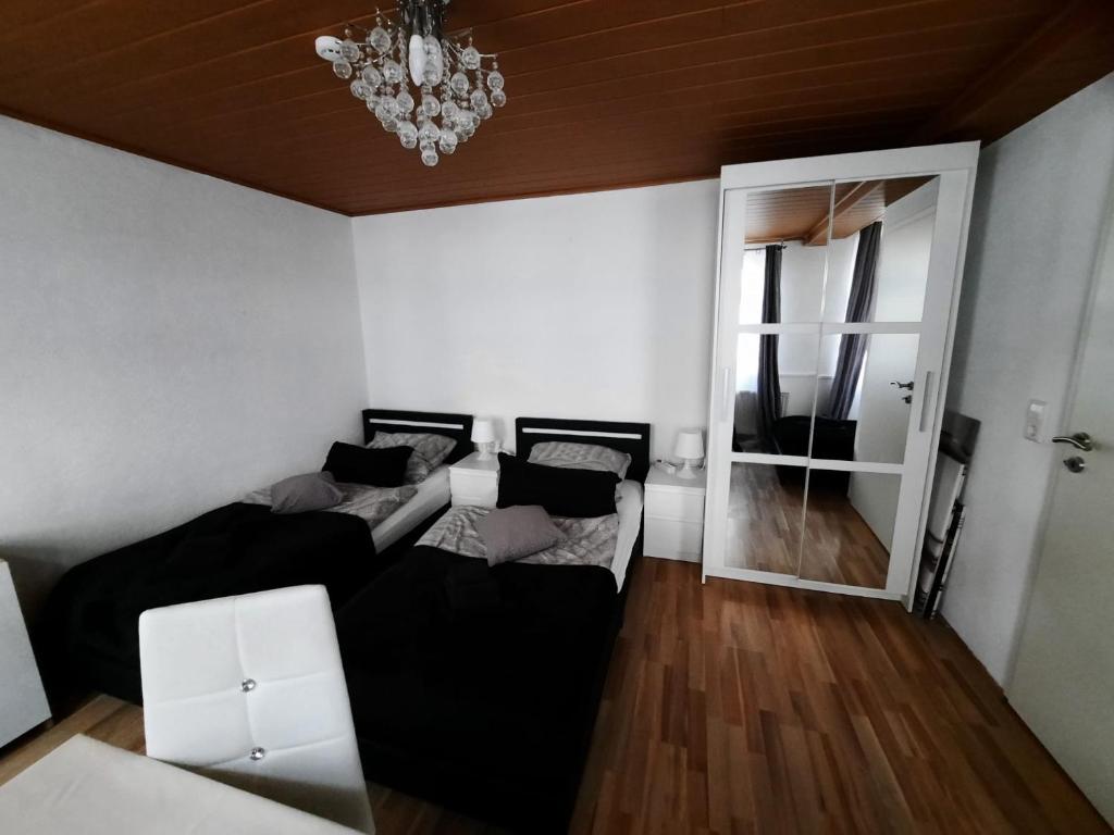 uma sala de estar com 2 camas e um lustre em Ferienwohnungen Calwer Höfle City - für Firmen, Handwerker und Monteure em Calw