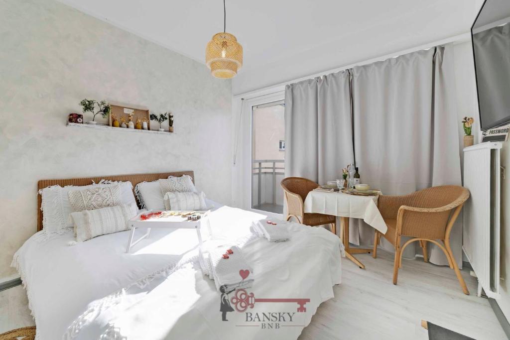 1 dormitorio blanco con 1 cama, mesa y sillas en Modern BOHO STYLE SUITE in Lugano City -By EasyLife Swiss en Lugano