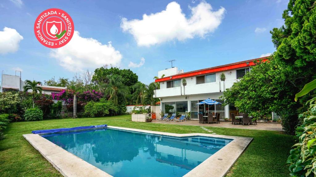 a villa with a swimming pool in front of a house at Casa Fujiyama Relax y Alberca bajo el sol in Cuernavaca