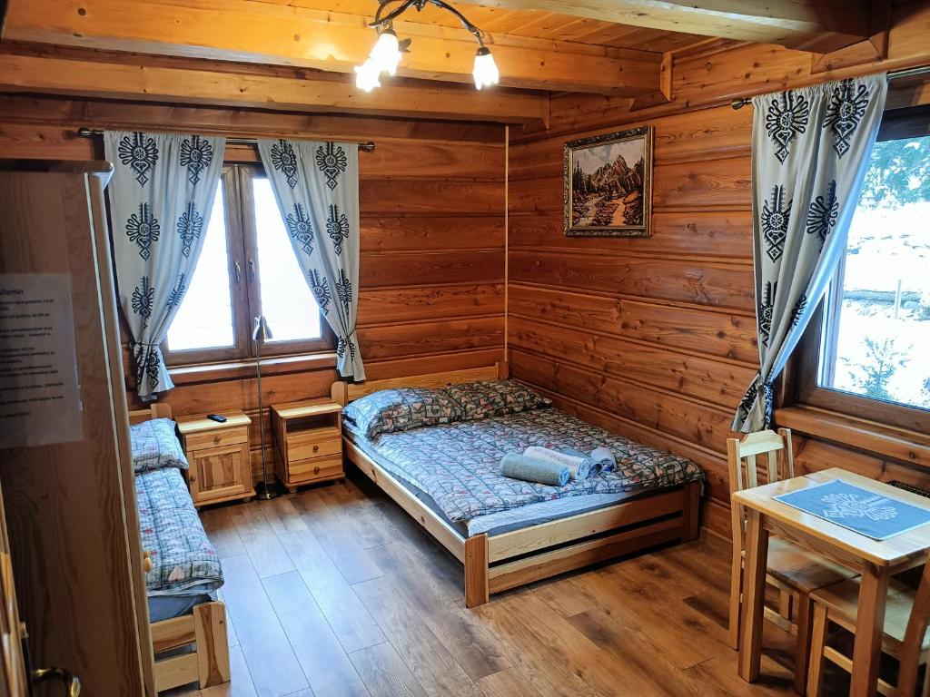 1 dormitorio con 1 cama en una cabaña de madera en uDany Noclegi obok Gondoli, en Szczyrk