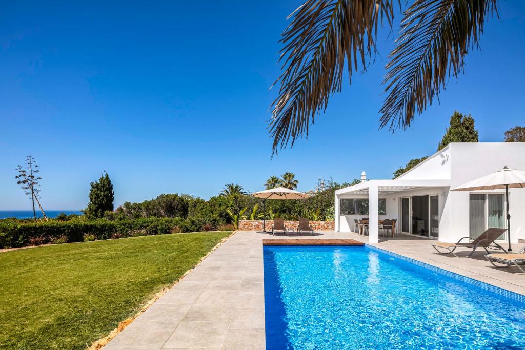 a swimming pool in front of a villa at Casa Guincho in Carvoeiro