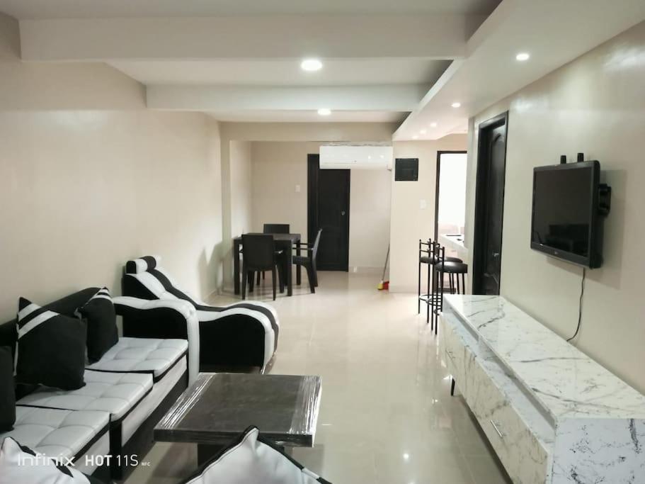 a living room with a couch and a tv and a table at Lindo apartamento in Daule