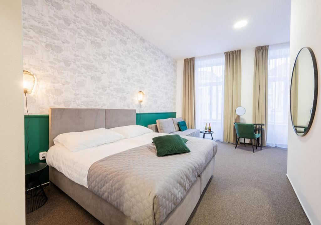 ein Schlafzimmer mit einem großen Bett mit einem grünen Kissen darauf in der Unterkunft Casa in Hradec Králové