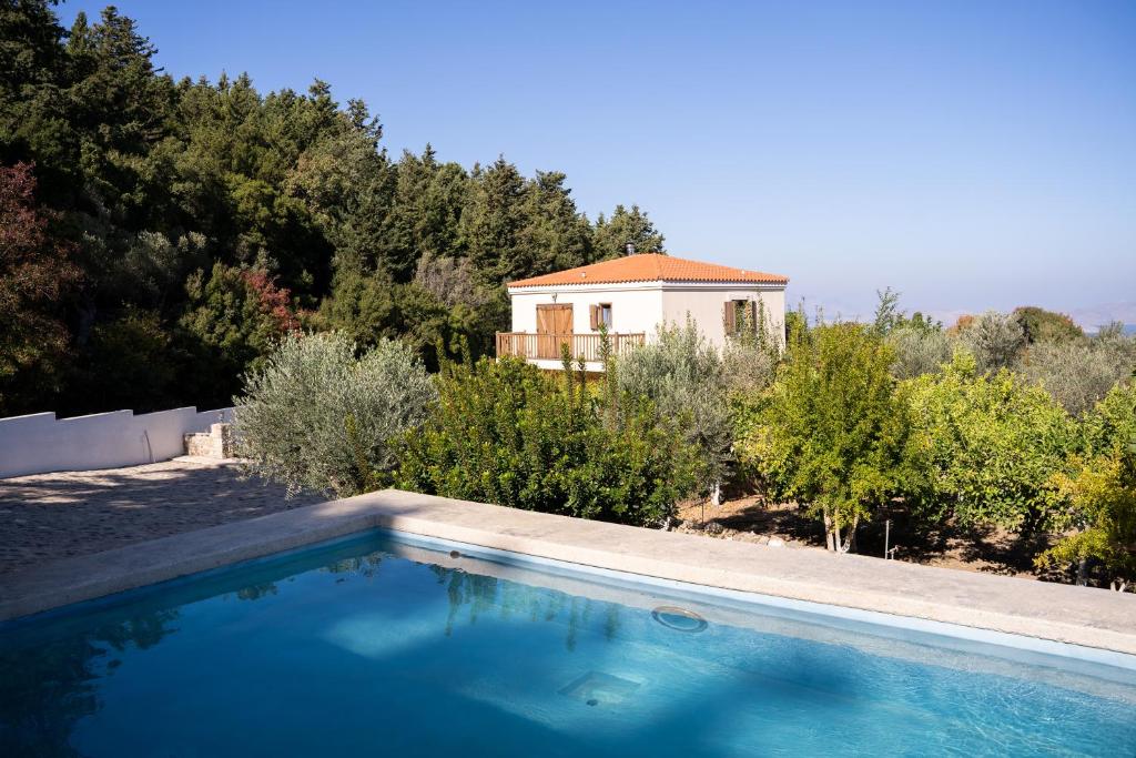 a swimming pool in front of a house at Chaihoutes stone villa into Olive farm in Zia in Ágios Dimítrios