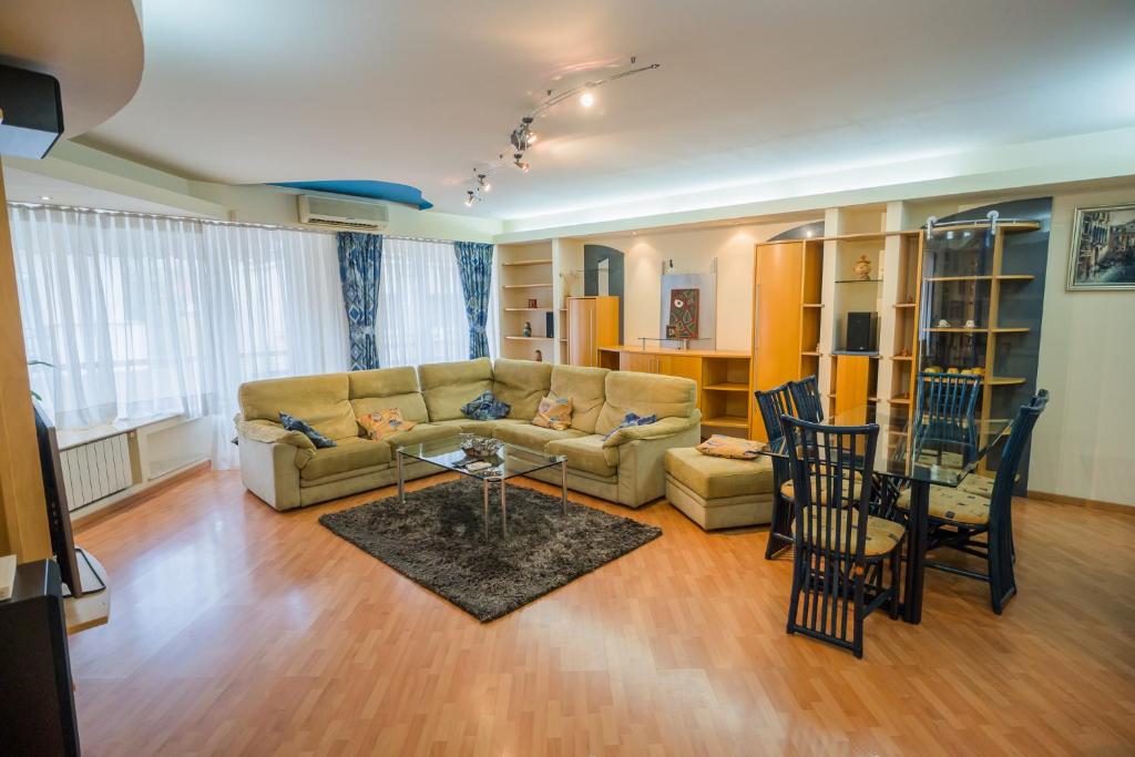 a living room with a couch and a table and chairs at Artsy 3BR flat in Primaverii - most exlcusive area in Bucharest