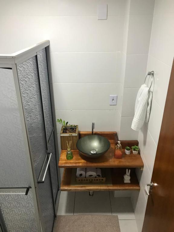 ein Badezimmer mit einem grünen Waschbecken auf einem Holztisch in der Unterkunft Apartamento encantador em bairro Nobre. in Santa Cruz do Sul