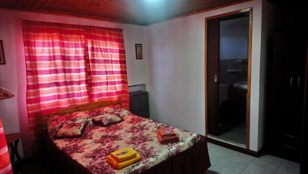 Dormitorio pequeño con cama y espejo en Del Cabo B&B en Ushuaia