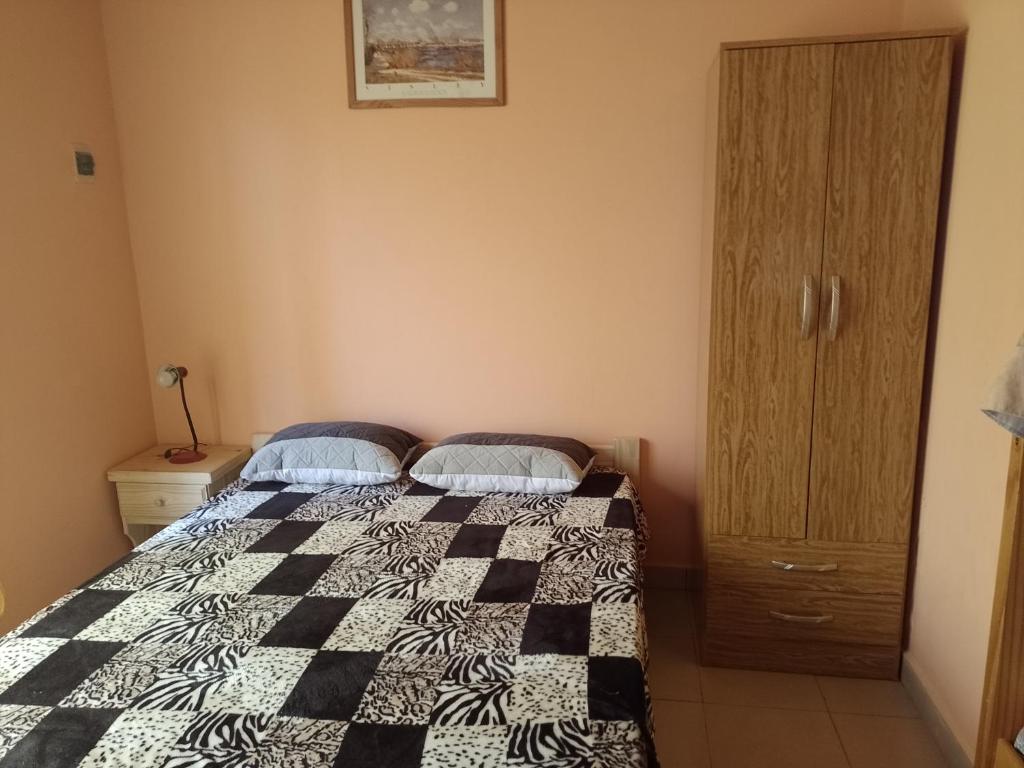 1 dormitorio con 1 cama con edredón blanco y negro en La Positiva en Mar de Ajó