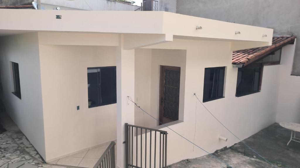 un edificio blanco con ventanas laterales en O Guardião-Casa no centro de São Thomé das Letras, en São Thomé das Letras