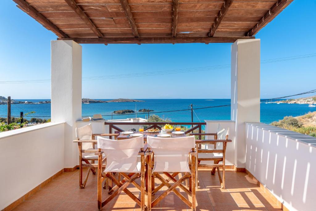 a balcony with a table and chairs and a view of the ocean at Reggina's Apartments in Finikas