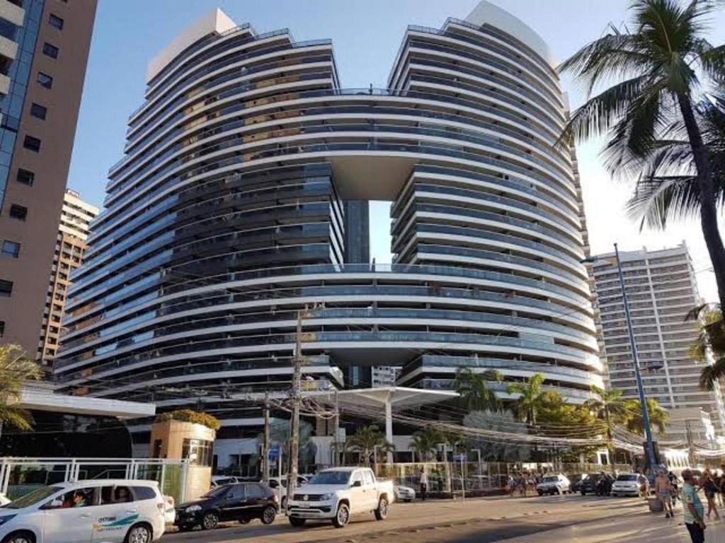 a large building with cars parked in front of it at LANDSCAPE - Beira mar platinum in Fortaleza