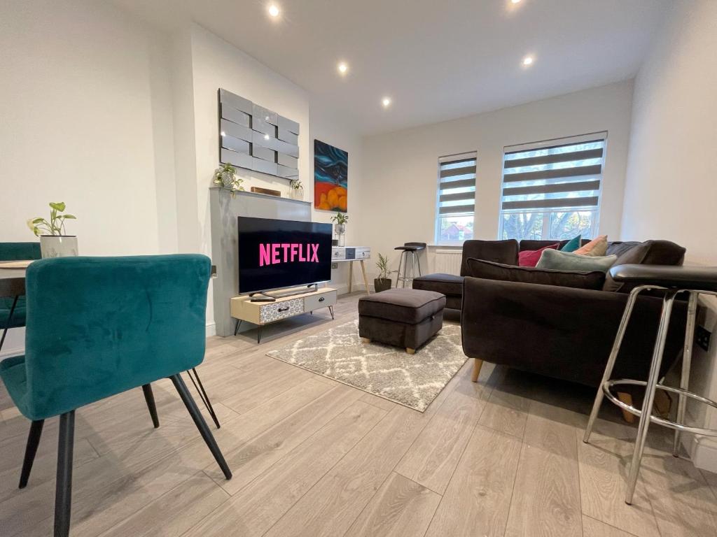 ein Wohnzimmer mit einem Sofa und einem TV in der Unterkunft Lovely and comfy entire 1 bedroom flat - 1st floor in Harrow on the Hill