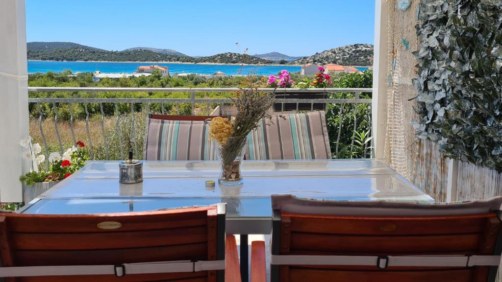 een tafel en stoelen met uitzicht op de oceaan bij Apartmani Villa Lilliana in Tribunj