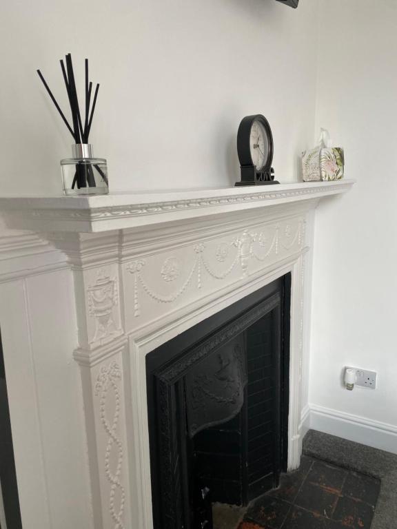 a fireplace with a clock on top of it at Ship Inn Stays Ltd in Wylam