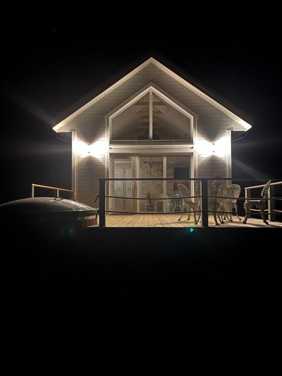 a house with lights on the front porch at night at Relax House By The Stone in Nugariai