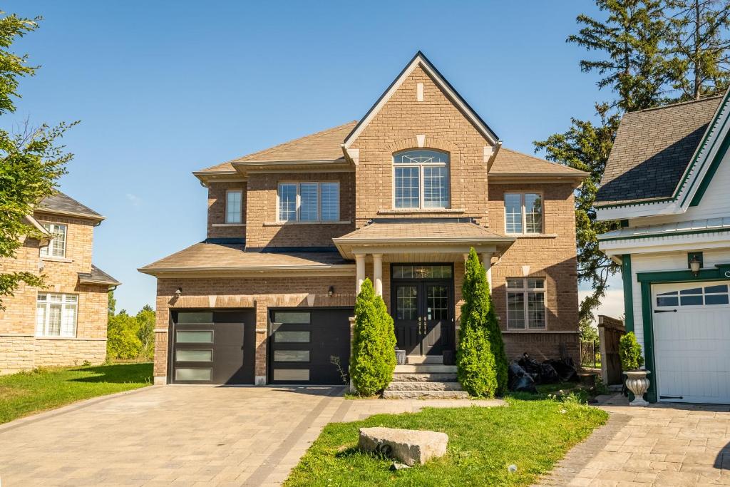 a brick house with a garage at Beautiful Family Villa, Pond Facing with Huge Backyard in Brampton