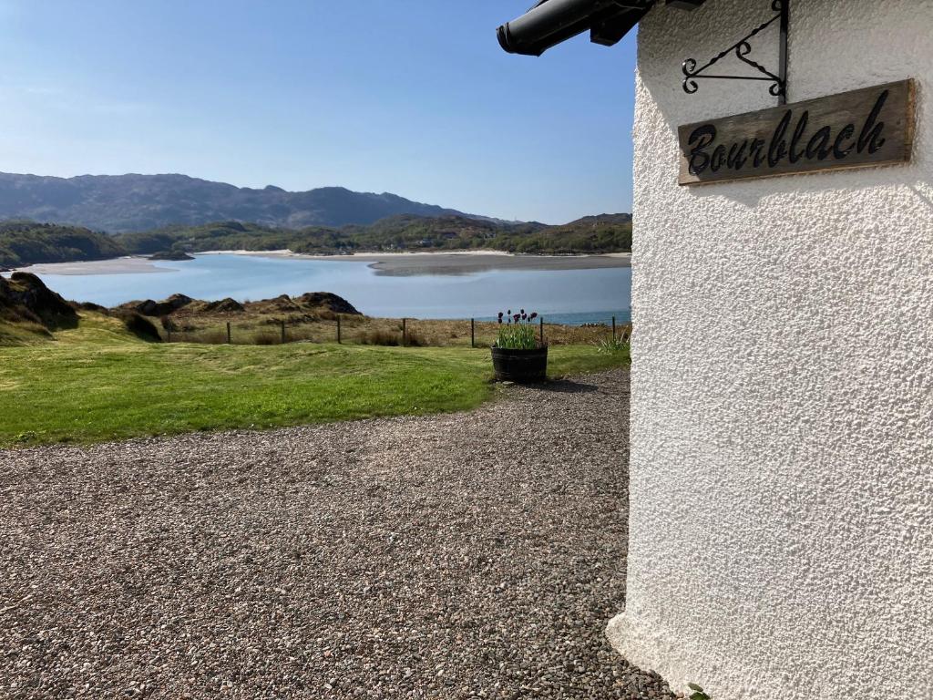a sign on the side of a building with a lake at Bourblach in Mallaig