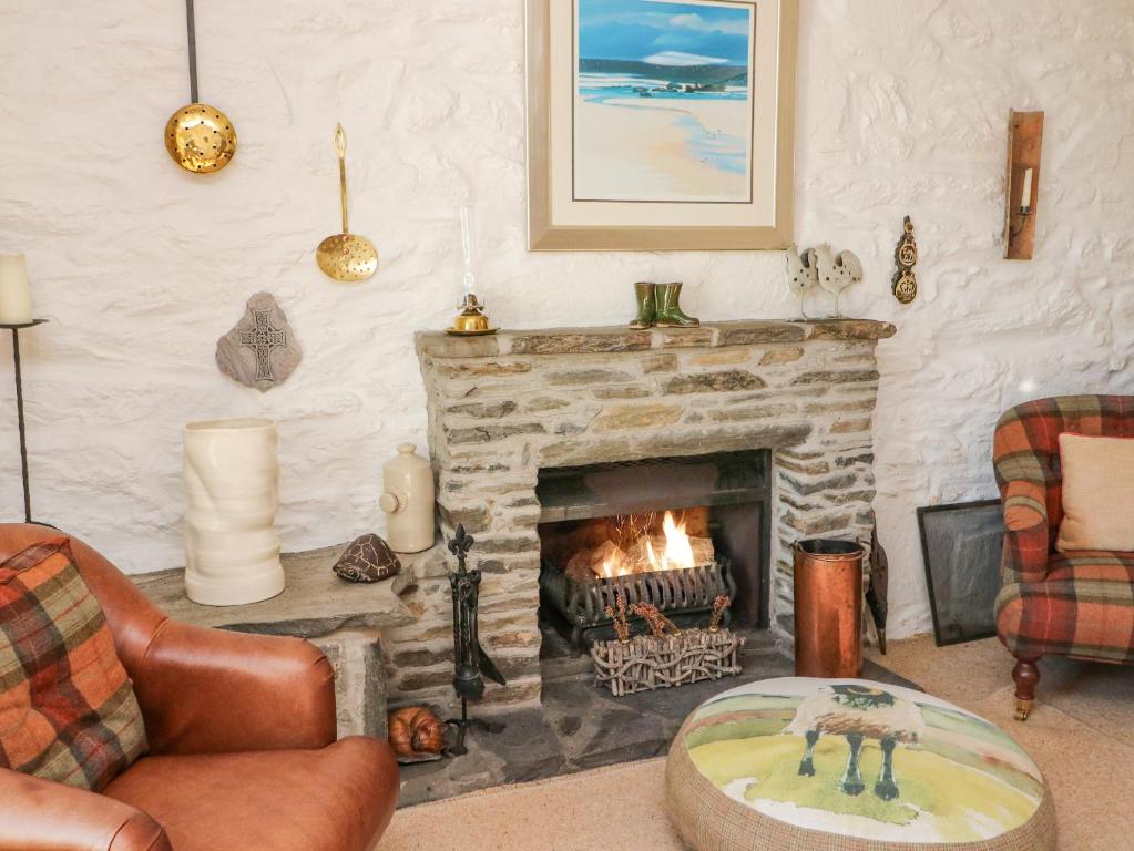 a living room with a fireplace and a couch and chairs at Bourblach in Mallaig