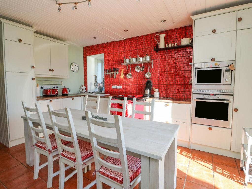 a kitchen with a table and chairs and red tiles at Bourblach in Mallaig