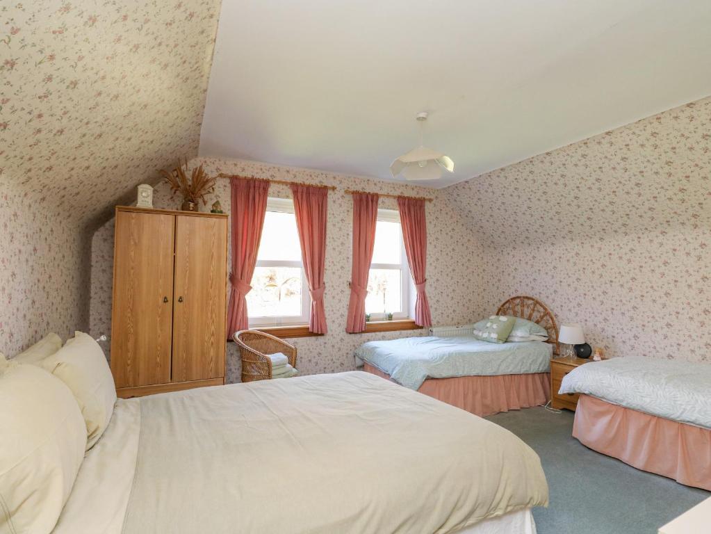 a bedroom with two beds and two windows at Bourblach in Mallaig
