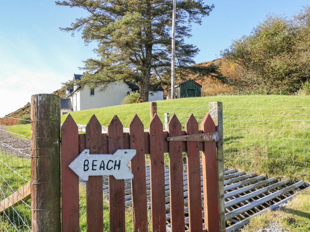 a wooden fence with a beach sign on it at Bourblach in Mallaig