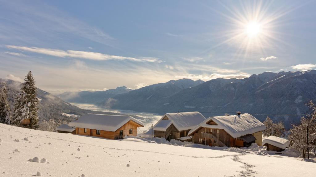 eine schneebedeckte Hütte auf einem schneebedeckten Berg in der Unterkunft Panoramahof am Goldberg in Dellach