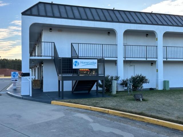 a building with a sign in front of it at Homelodge Newnan in Newnan