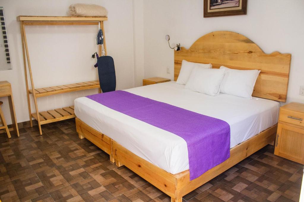 a bedroom with a large bed with a wooden headboard at Casa Gubidxa in Oaxaca City
