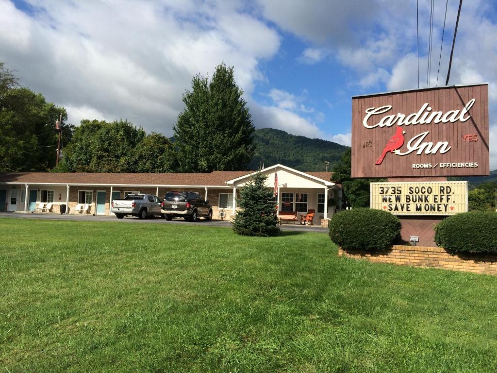 a sign in front of a building with a car dealership at Cardinal Inn in Maggie Valley