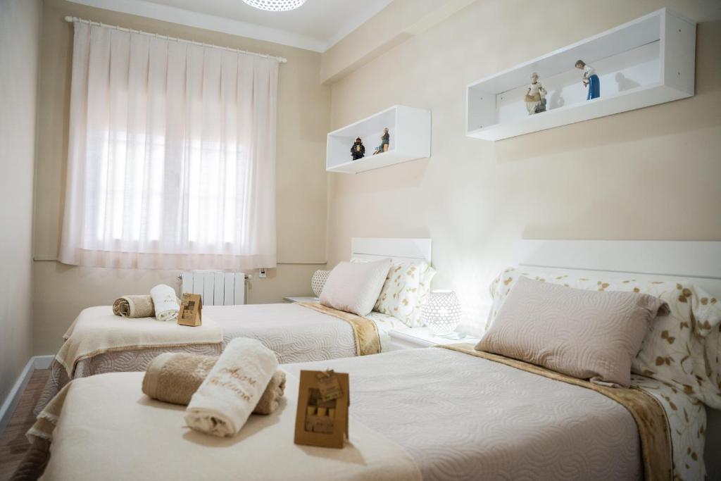 two beds in a room with white walls at Gallimó Apartaments in L'Ampolla