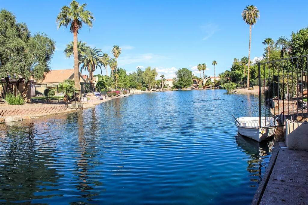 a boat is docked on a river with palm trees at Lakefront Hacienda w/ Paddle Boat, Pool, Hot-tub, Tennis in Chandler