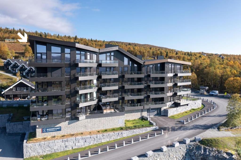 an apartment building with a road in front of it at Top notch leilighet med panoramautsikt in Beitostøl