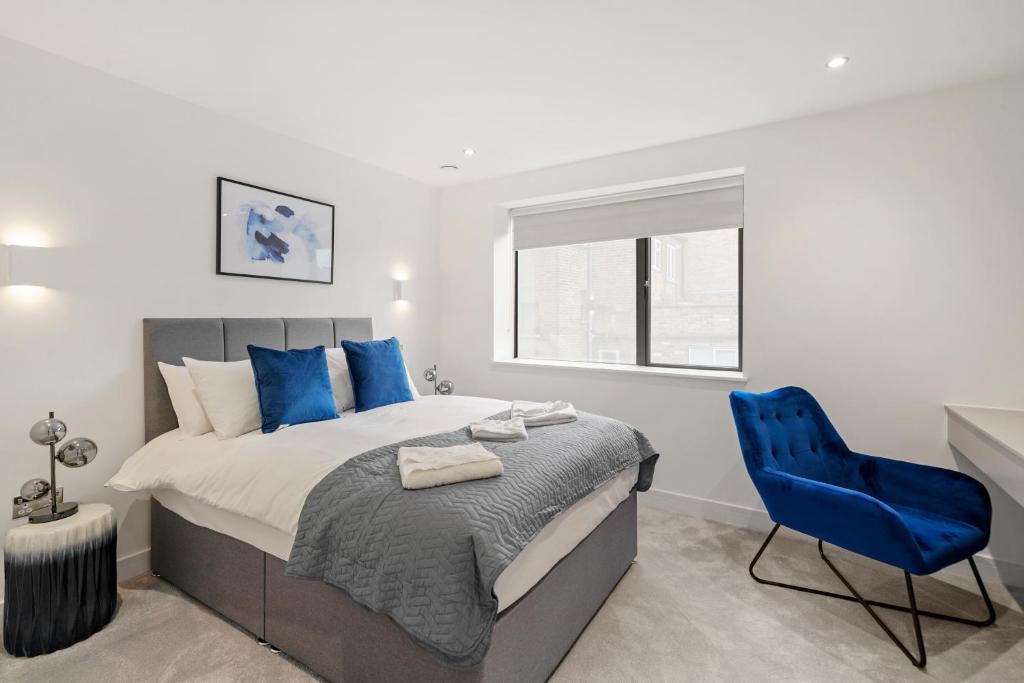 1 dormitorio con 1 cama y 1 silla azul en Executive 1 & 2 Bed Apartments in heart of London FREE WIFI by City Stay Aparts London en Londres