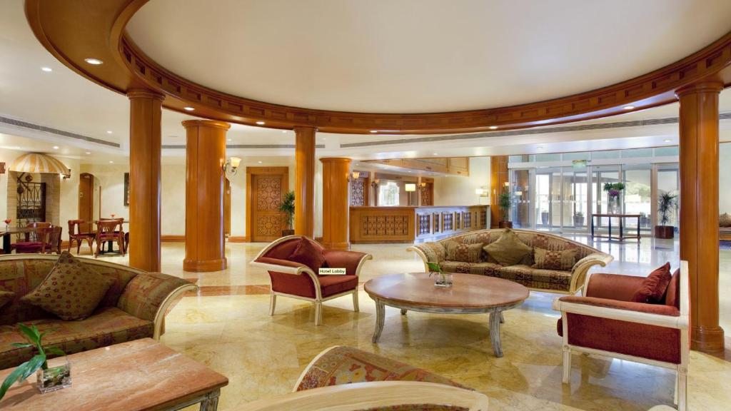 a lobby with couches and a table and chairs at Holiday Inn Al Khobar, an IHG Hotel in Al Khobar