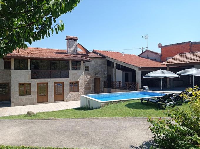 una casa con piscina frente a ella en Solar da Benedita, 
