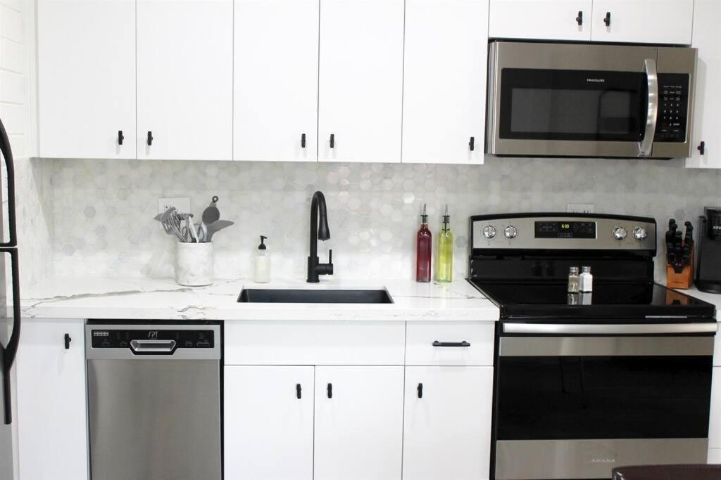 a kitchen with white cabinets and a stove and a microwave at Remodeled Modern Ground Level Apt Blocks to Dwntn - B in Tempe