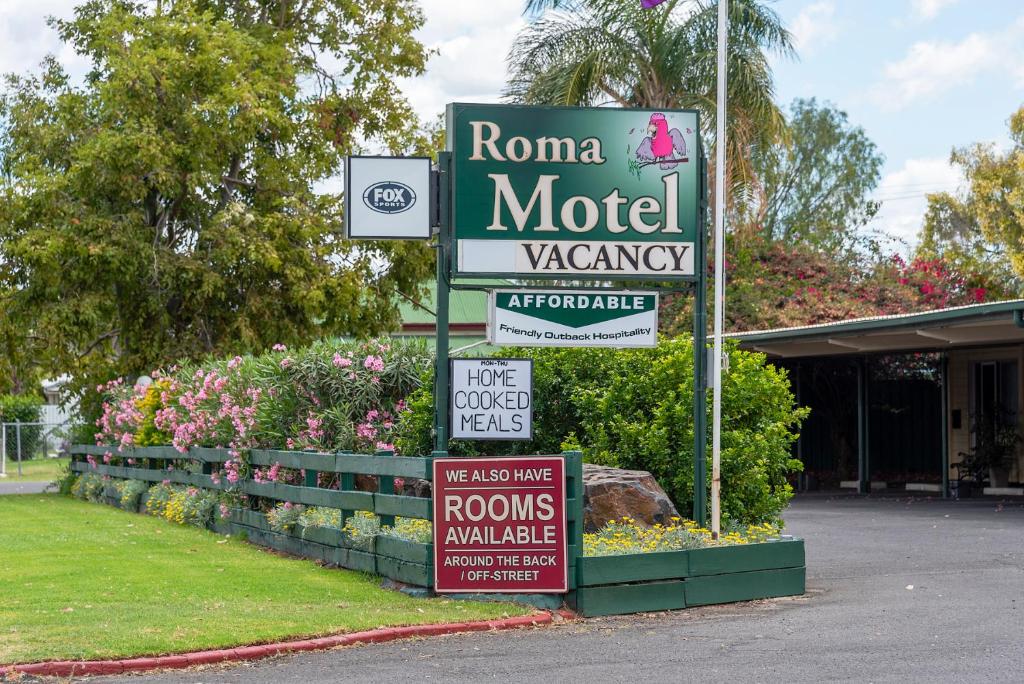 una señal para un motel con señales en él en Roma Motel, en Roma