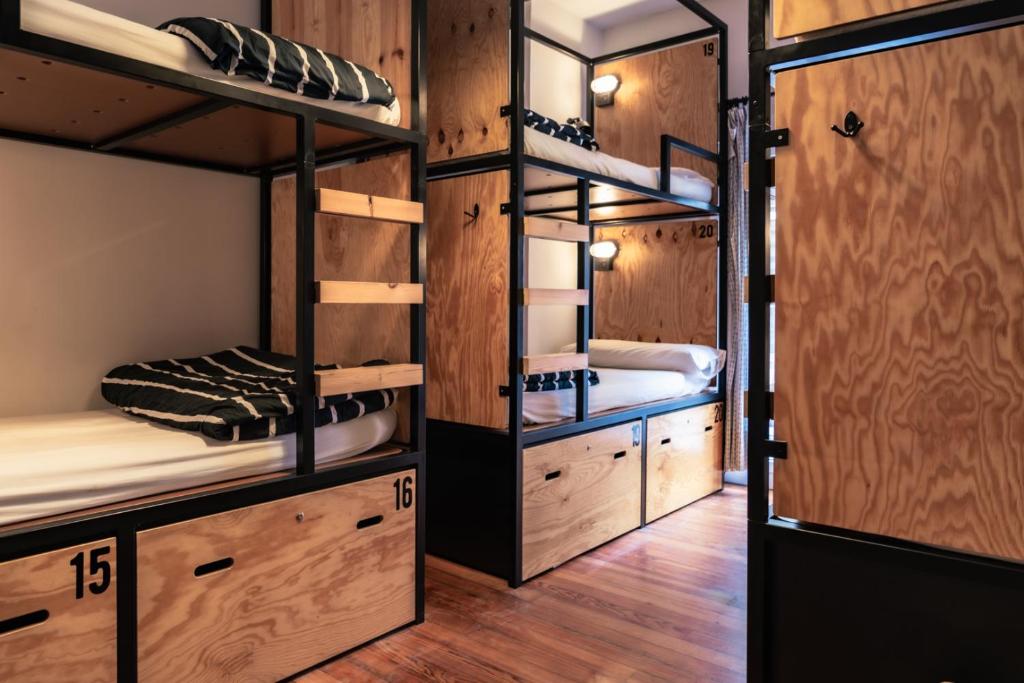 a room with four bunk beds and wooden walls at Surfing Etxea - Surf Hostel in San Sebastián