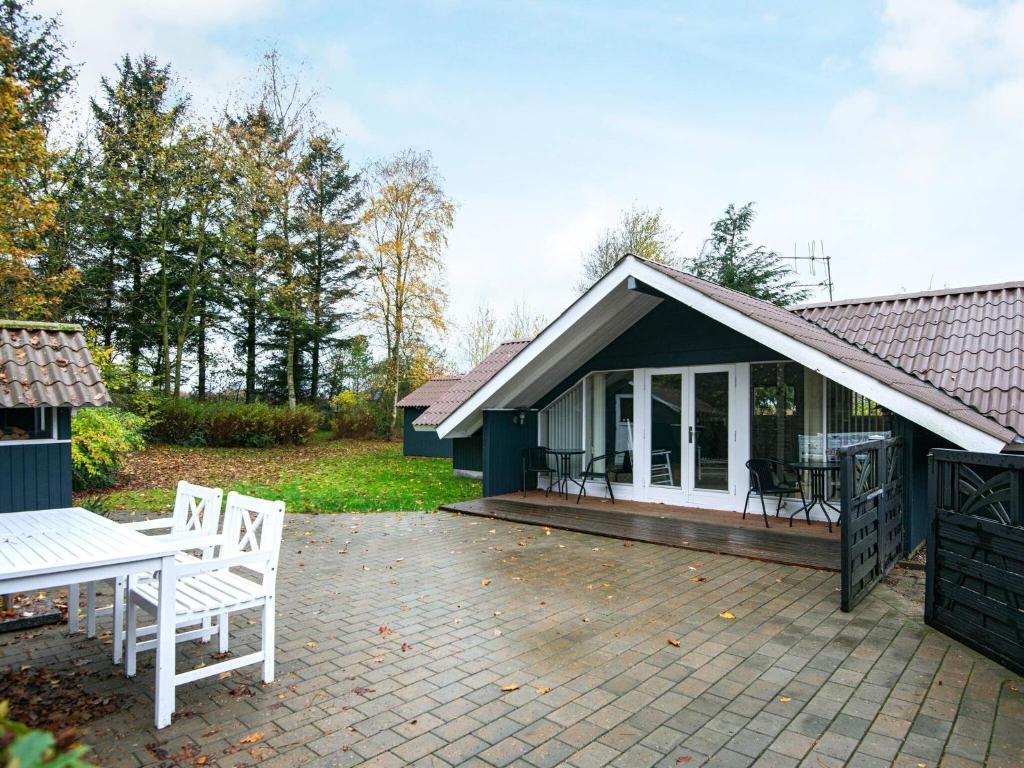 a house with a patio with a table and chairs at Holiday home Ansager XLIII in Ansager