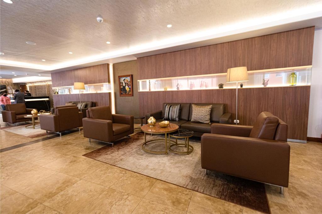 un vestíbulo con sofás, sillas y una mesa en Hotel Presidente Huancayo - Asociado Casa Andina, en Huancayo