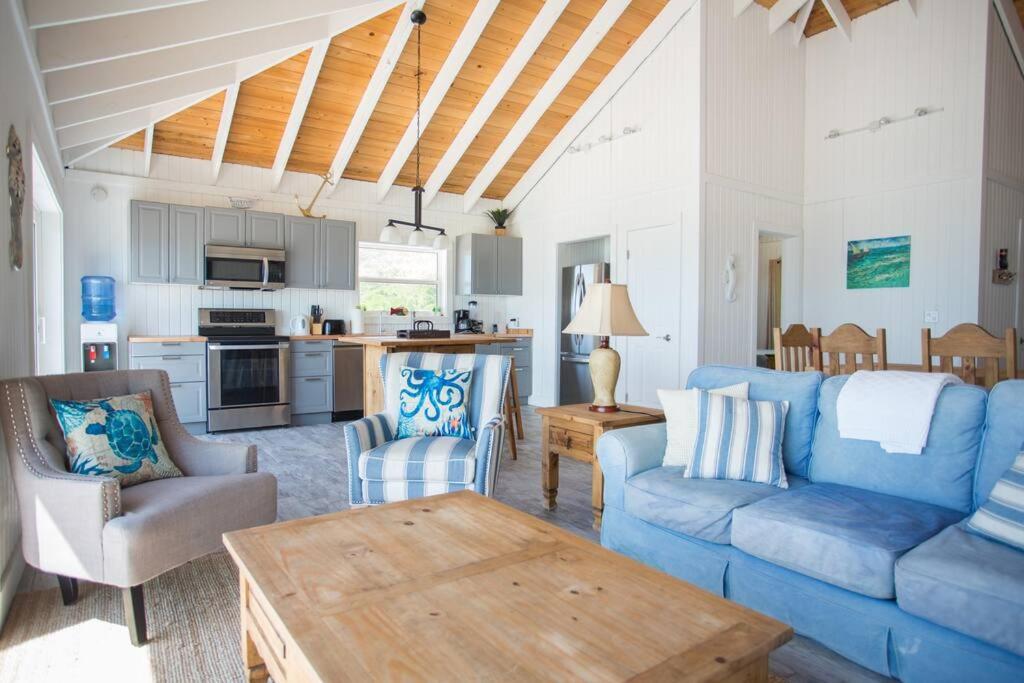 sala de estar con sofá azul y mesa en Sunset Cove en Forbes Hill