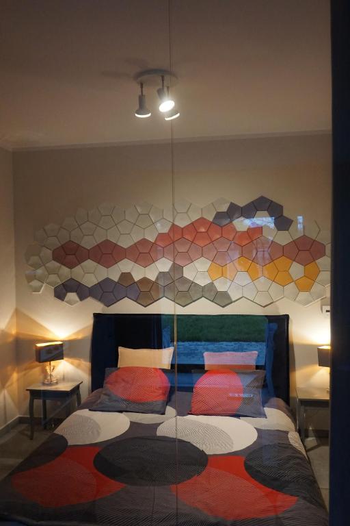 ein Schlafzimmer mit einem Bett mit einer Mosaikwand in der Unterkunft Apartament Zakatek z ogrodkiem i miejscem w garazu podziemnym in Bielsko-Biała