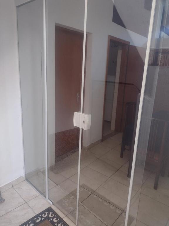 um chuveiro de vidro num quarto com piso de azulejo em Apartamento térreo chique em Guaratinguetá