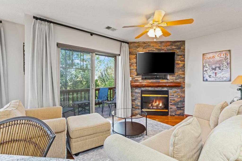a living room with a fireplace and a tv at Jordanelle Jubilee in Heber City