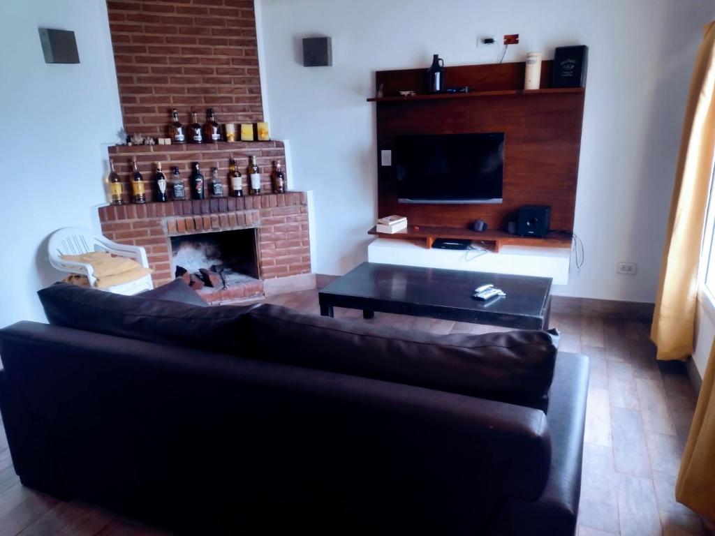 sala de estar con sofá y chimenea en Mar y campo en Mar del Sur