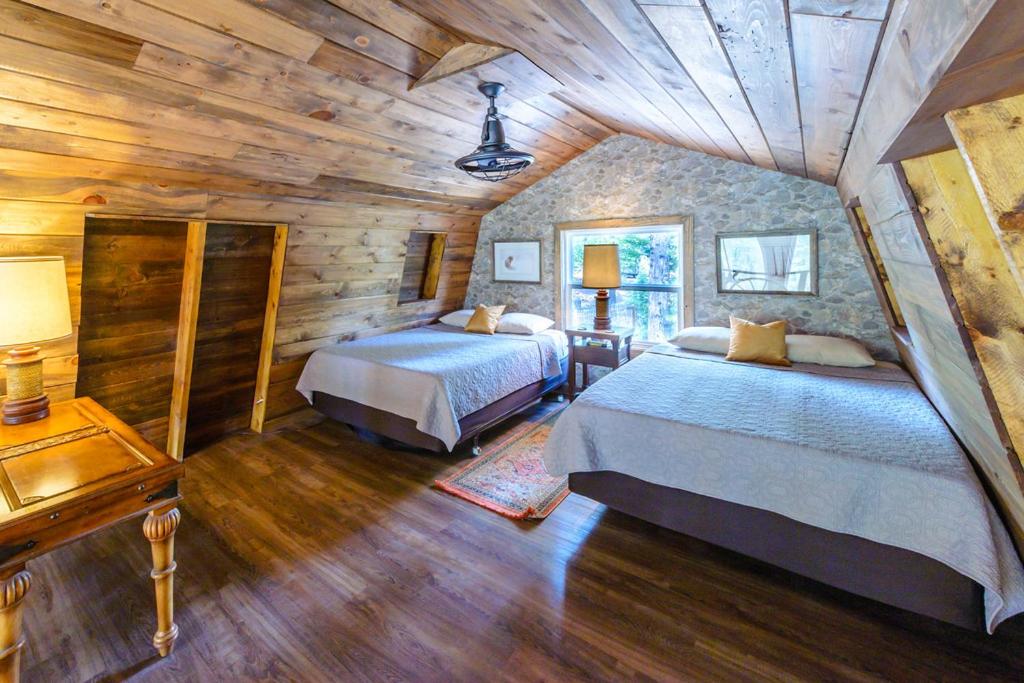 a bedroom with two beds in a log cabin at Cozy Cabin Near Bryce and Zion sleeps 4 adults in Duck Creek Village