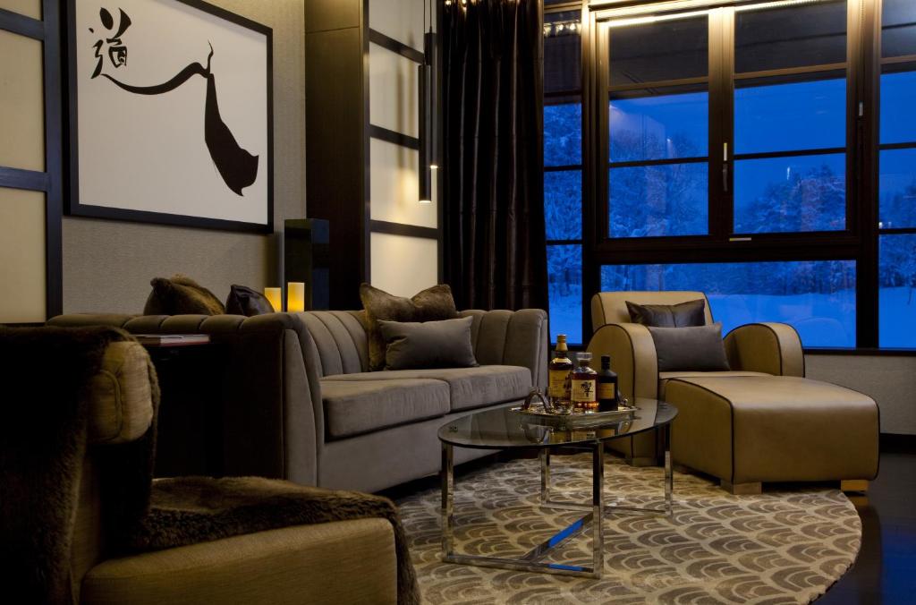 a living room with couches and a table and a window at Kasara Niseko Village Townhouse - Small Luxury Hotels of The World in Niseko